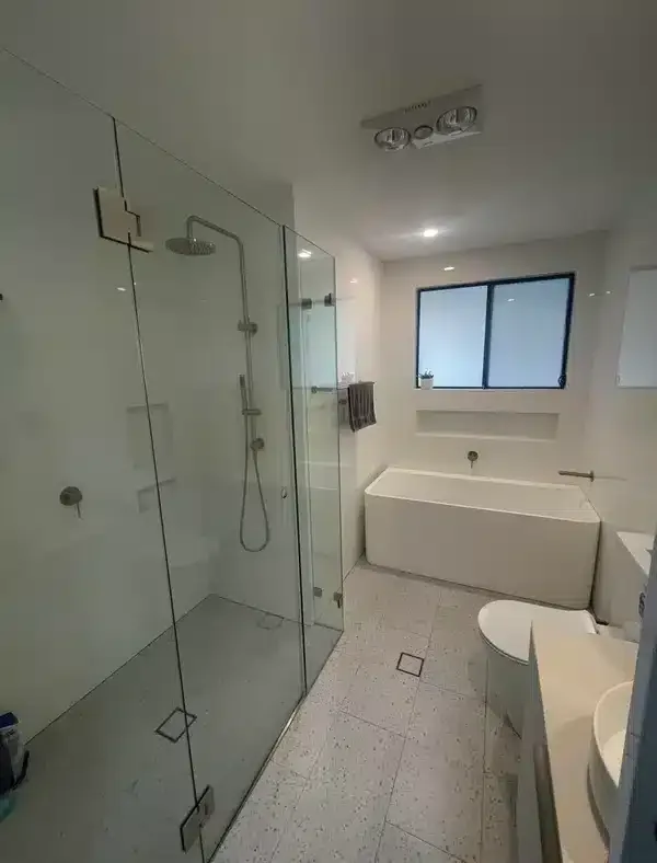 Round backlit mirror above a black timber vanity