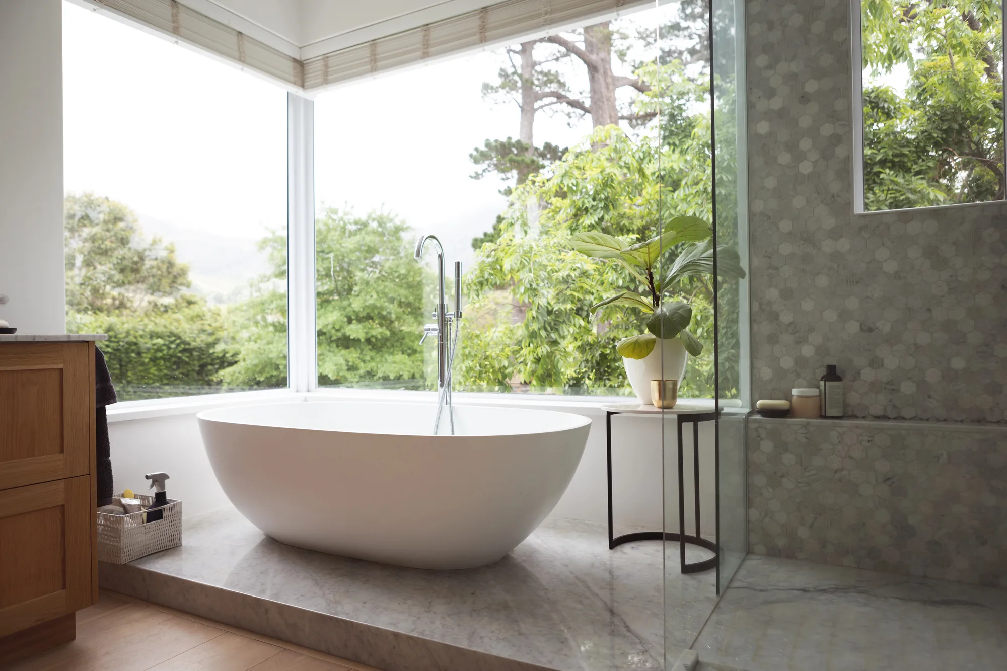 Freestanding bath beside large windows in a finished bathroom renovation