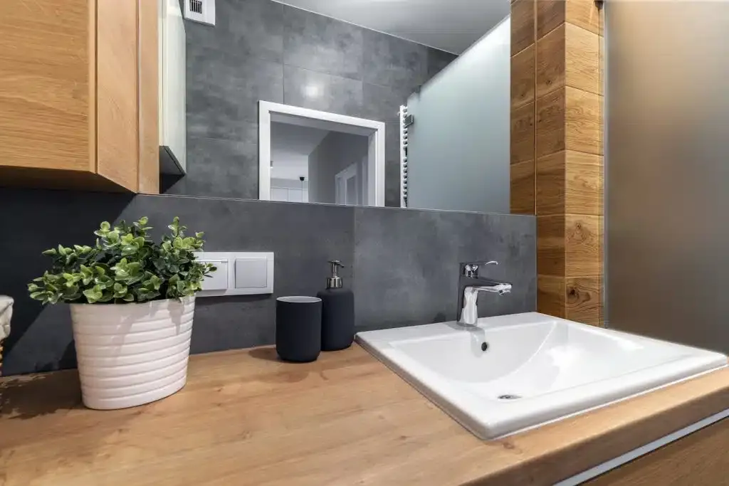 Close-up of a compact ensuite vanity corner with a vessel sink and timber cabinetry