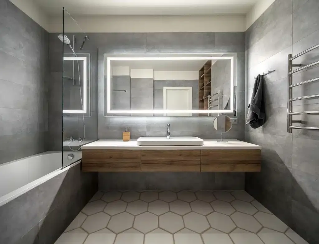 Modern bathroom with a backlit rectangular mirror, timber vanity and hexagon floor tiles