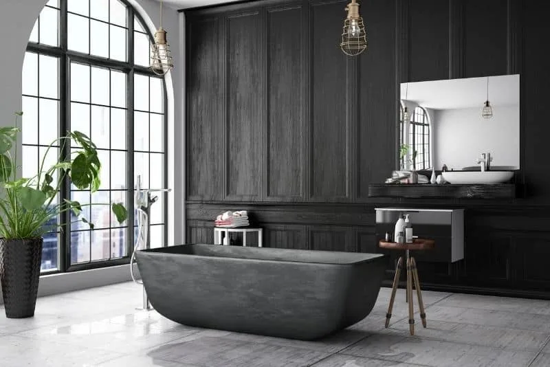 Moody dark-panelled bathroom with a black freestanding bath